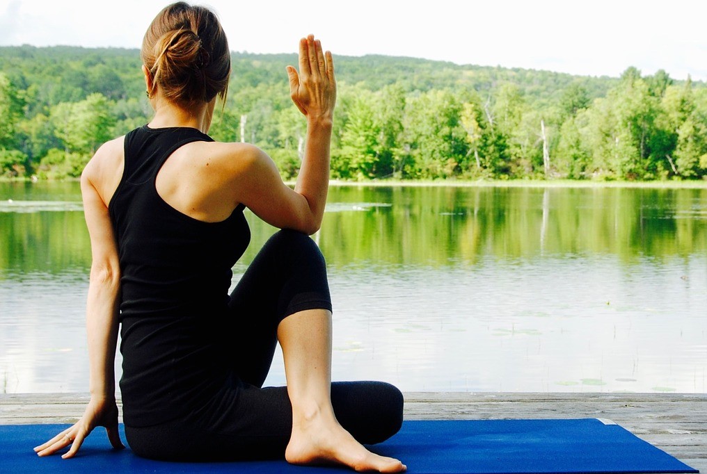 Woman doing yoga by the waterfront